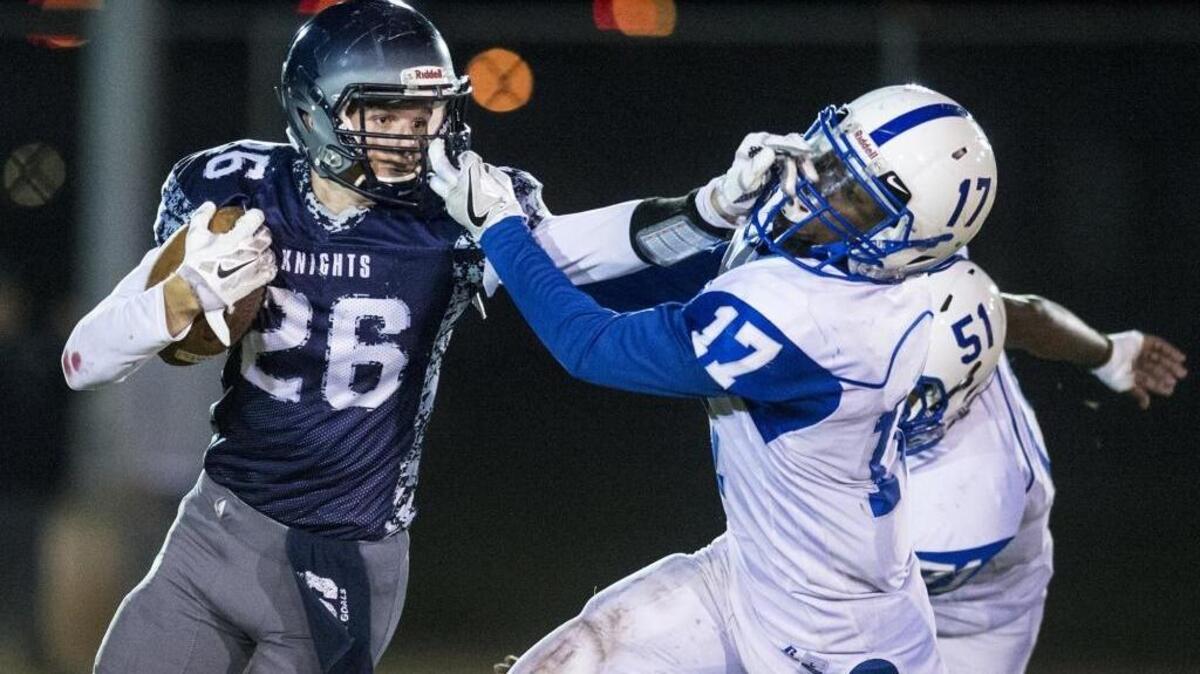Stone Ridge Christian senior Cole Houweling (26) stiff-arms Brookside Christian senior Stedman Quartermaine (17) during a a Sac-Joaquin Section Division VII playoff game at Castle Field in Atwater, Calif., on Thursday, Nov. 9, 2017. Stone Ridge Christian beat Brookside Christian 50-13.