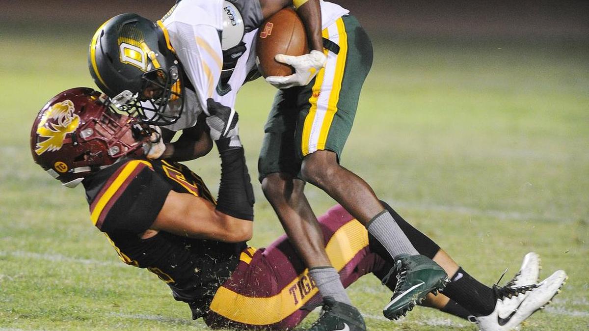 Los Banos Izaiah Flores, left, tackles Davis High wide receiver Gregory Smith in the second quarter Fri., Sept. 21, 2018 at Loftin Stadium in Los Banos.