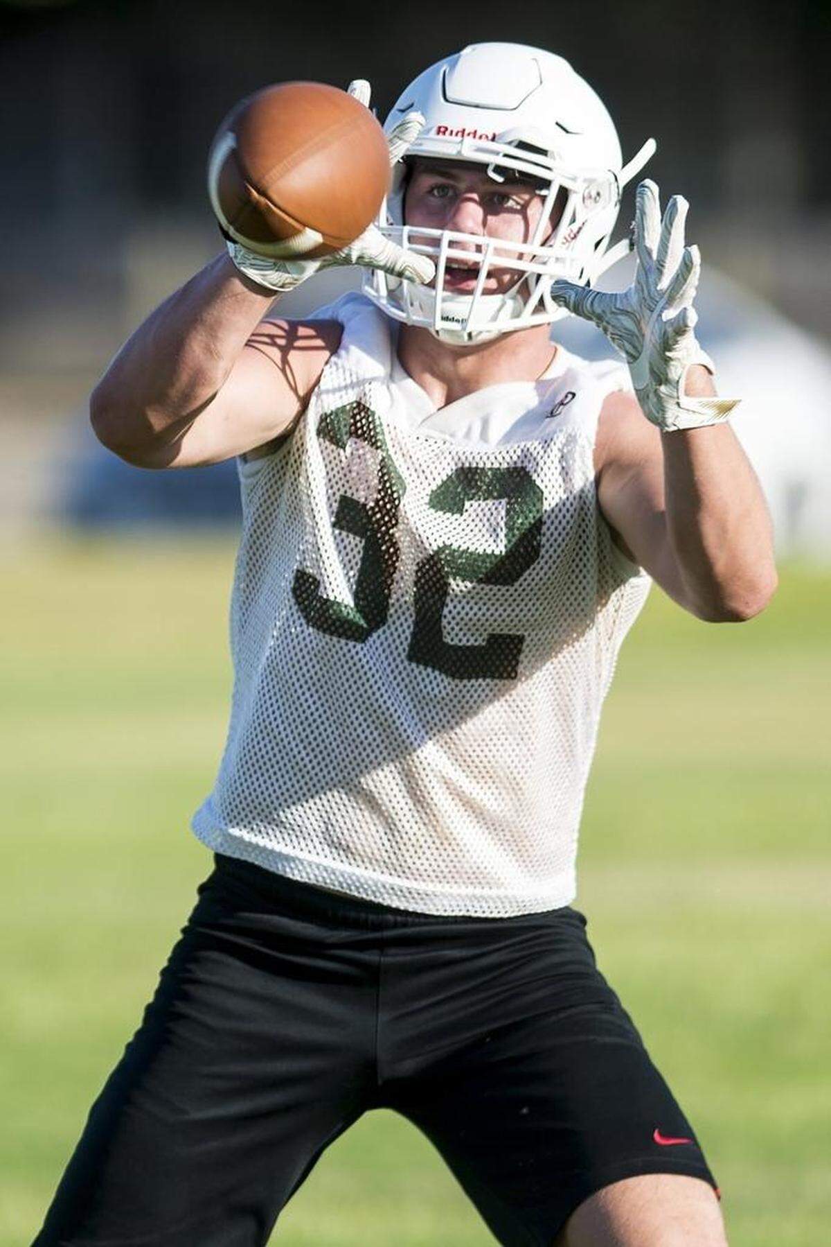 Hilmar’s Justin Rentfro attempts to catch a pass during football practice at Hilmar High School in Hilmar, Calif., on Wednesday, July 25, 2018.