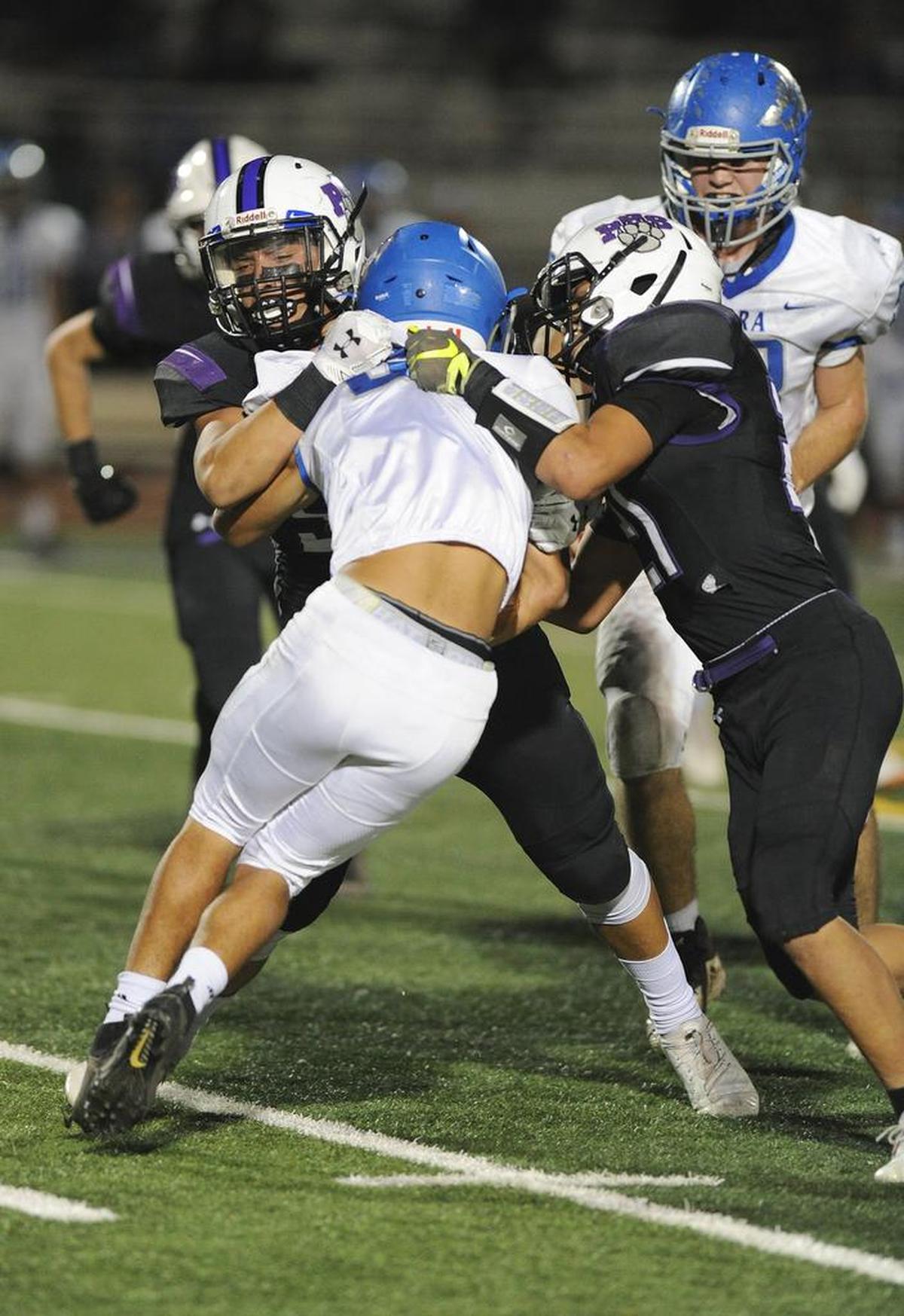Two Pacheco High School tacklers stop a Sierra High runner Fri., Nov. 2, 2018 at Veterans Stadium in Los Banos.