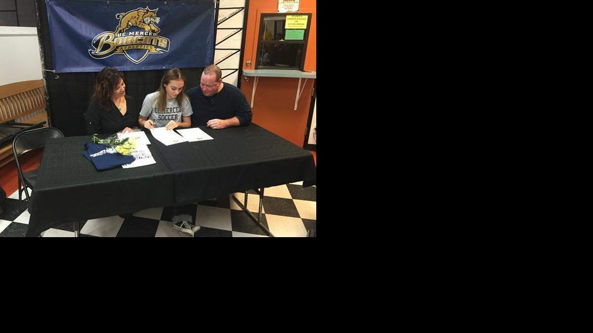 
Merced High senior Niccole Salm signs her national letter of intent to play soccer at UC Merced on Monday night at Merced High while her mother, Michelle, and father, John, look on.
