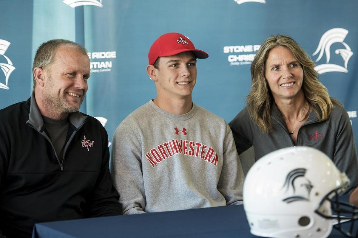 Stone Ridge Christian senior Cole Houweling, center, sits with parents Len, left, and Karla, right, after signing his letter of intent to attend Northwestern College in Iowa, at Stone Ridge Christian High School in Merced, Calif., on Thursday, March 15, 2018.