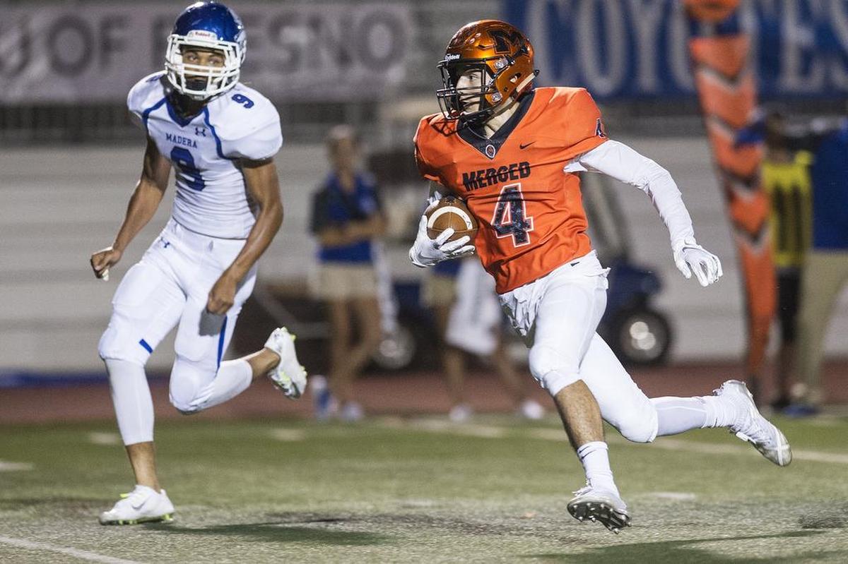 Merced senior Ezra Morales (4) gains yards after catching a pass during a game against Madera at Veterans Stadium on the campus of Golden Valley High School in Merced, Calif., on Friday, Sept. 7, 2018. The Bears beat the Coyotes 63-35.