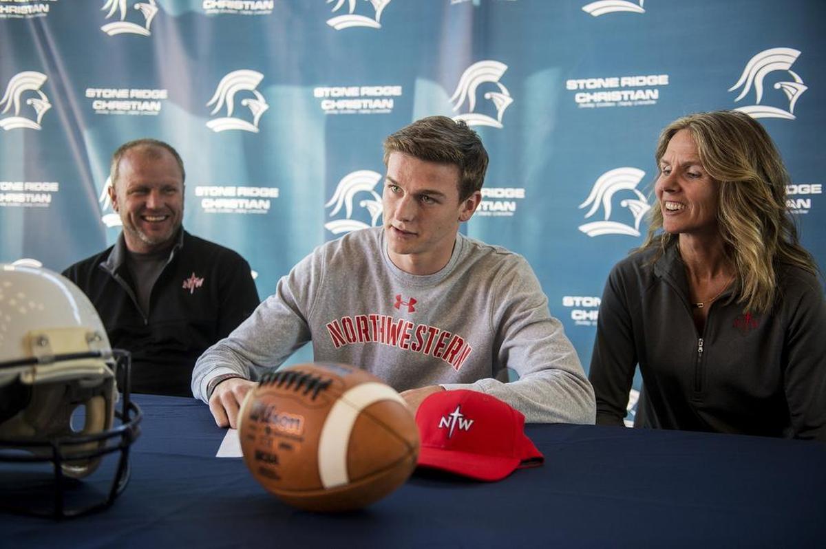 Stone Ridge Christian senior Cole Houweling, center, looks up after signing his letter of intent to attend Northwestern College in Iowa, next to parents Len, left, and Karla, right, at Stone Ridge Christian High School in Merced, Calif., on Thursday, March 15, 2018.