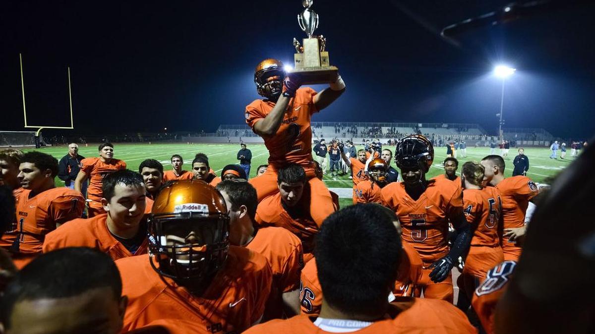 Merced senior running back Jabar Byrd (2) raises the Bernasconi Memorial Mayor’s Cup following a 53-14 win over Golden Valley at Veterans Stadium on the campus of Golden Valley High School in Merced, Calif., Friday, Nov. 7, 2014.
