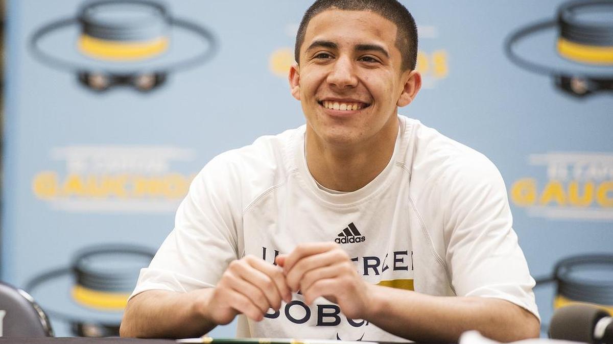 El Capitan senior Angel Serena smiles as friends and family take photos during a ceremony at El Capitan High School in Merced, Calif., on Friday, April 27, 2018. Serena signed his letter of intent to attend and play basketball at the University of California, Merced.