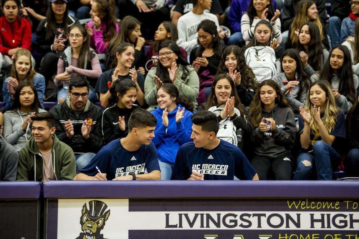 Livingston High School's Francisco Lopez, left, and Marco Sobrevilla, right, are applauded by fellow students during a ceremony in the school's gymnasium following the signing of their letters of intent to play soccer at the University of California, Merced at Livingston High School in Livingston, Calif., on Tuesday, April 17, 2018.