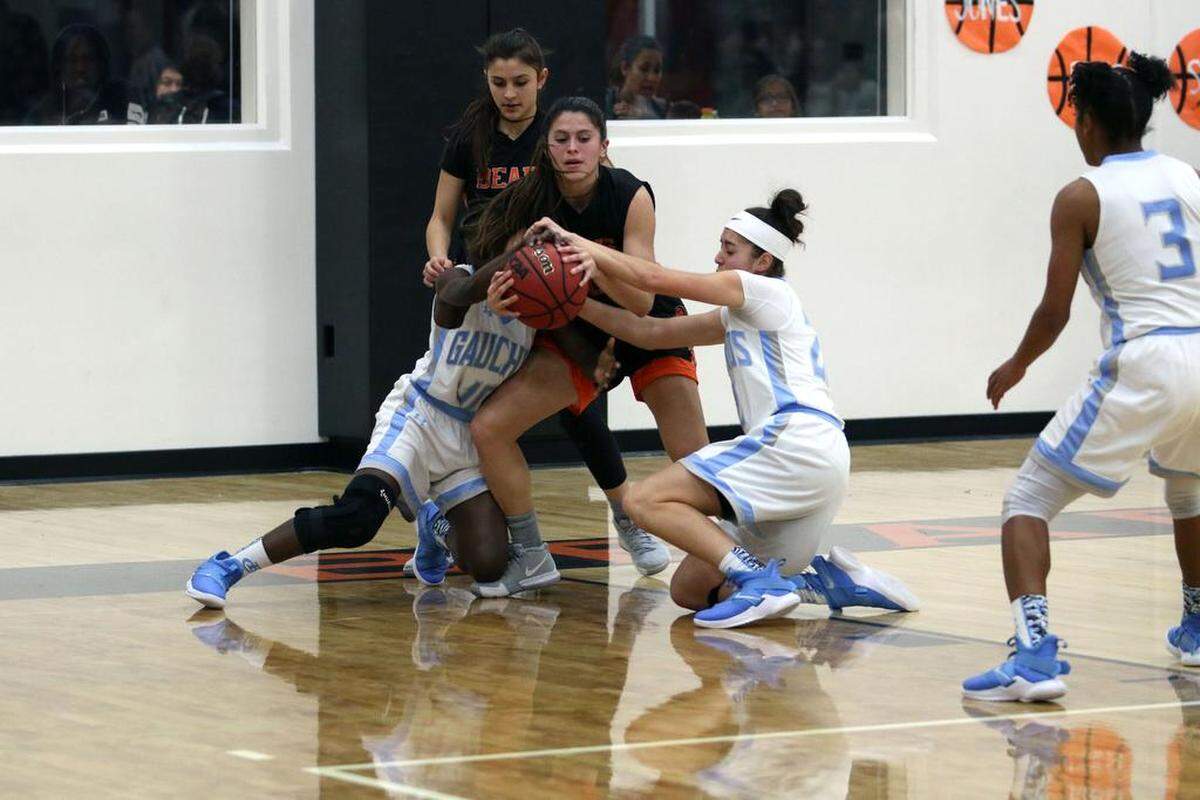 Merced High’s Kaitlynn Perez tries to protect the ball from two El Capitan players during the Gauchos’ 60-45 win over the Bears on Tuesday night at Merced High.